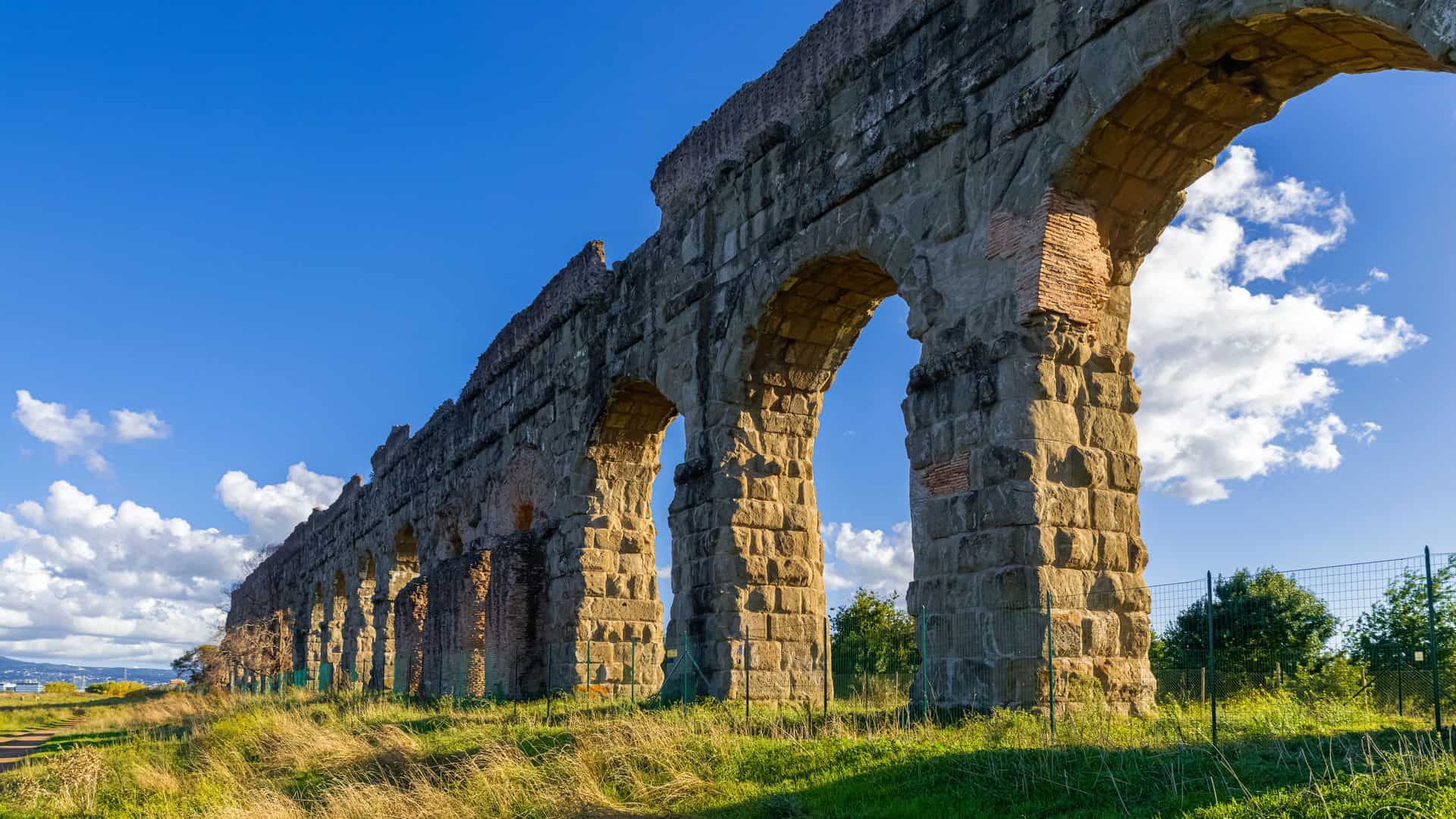 A view of an ancient aqueduct in a park in Rome.