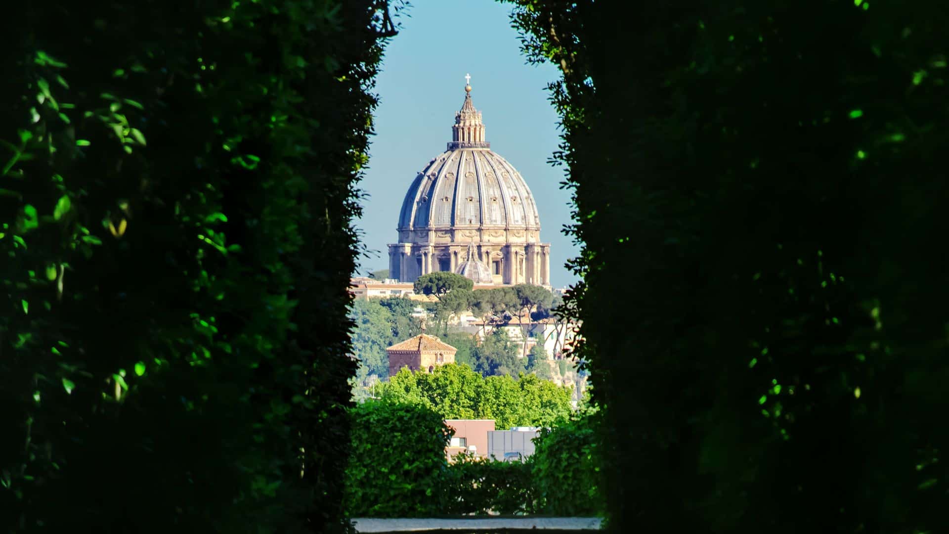 A view of St. Peter's Basilica framed by hedges from the Aventine Keyhole.