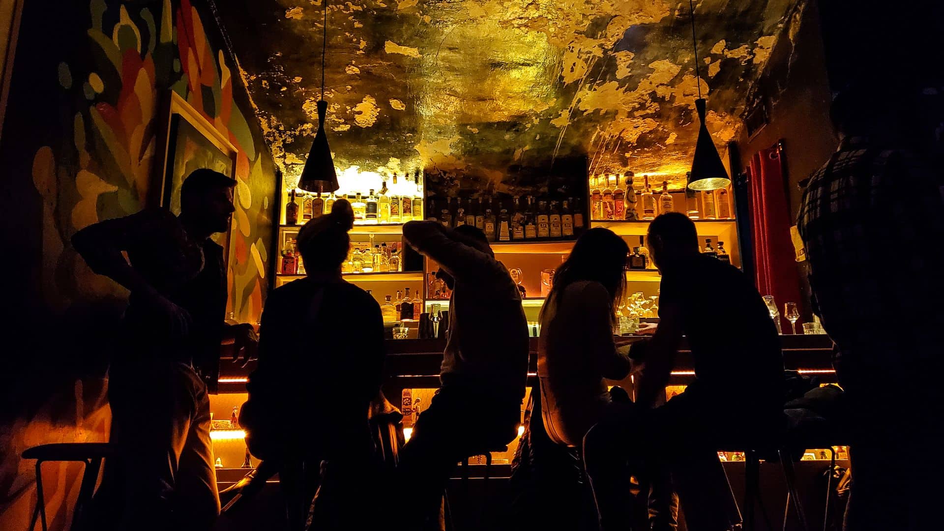Four people sit in a dark bar.