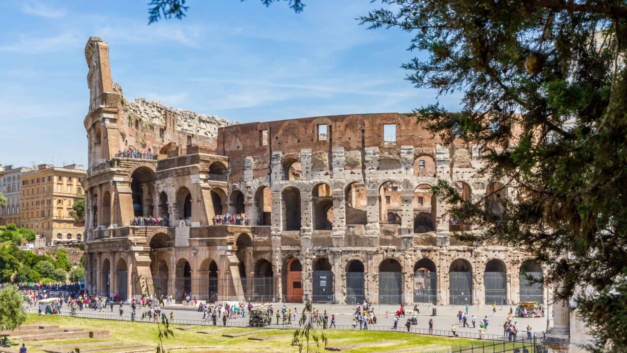 Tourists walking along the outer wall of the Roman Colosseum