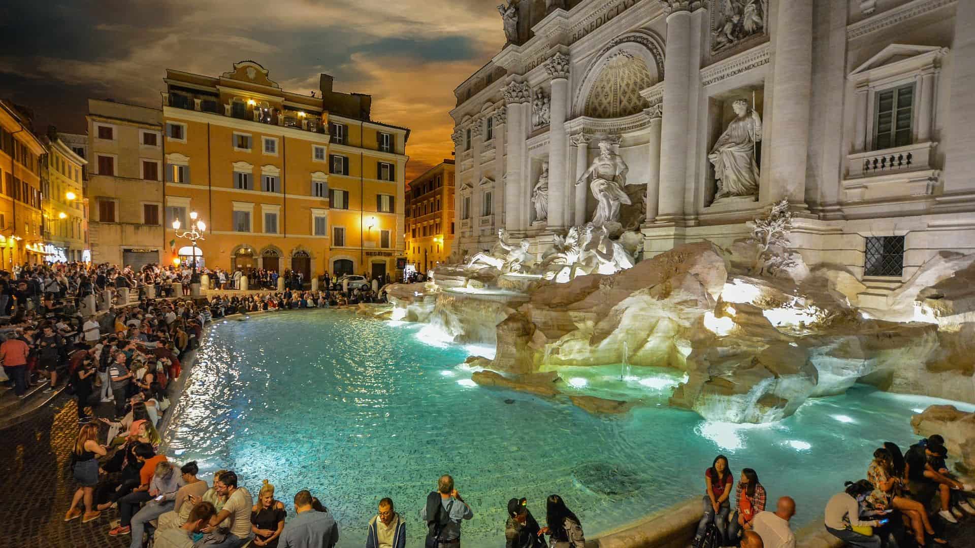 People visiting the Trevi Fountain at night